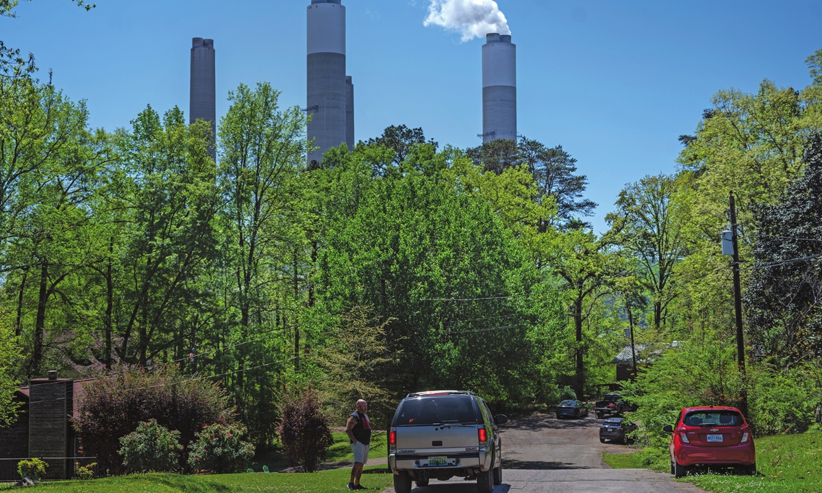 Fred Chesser Jr, 57, a coal miner speaks with his neighbor across from his house as steam rises from the Miller coal Power Plant in West Jefferson, Alabama, the US, on April 11. Photo: AFP