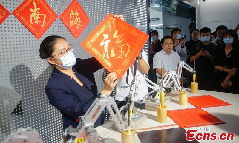 The calligraphy written by robot is presented by a staff member of Guangdong Xinbao Electrical Appliances Company in Foshan, a manufacturing powerhouse in Guangdong-Hong Kong-Macao Greater Bay Area(GBA), April 19, 2021.  Photo: China News Service