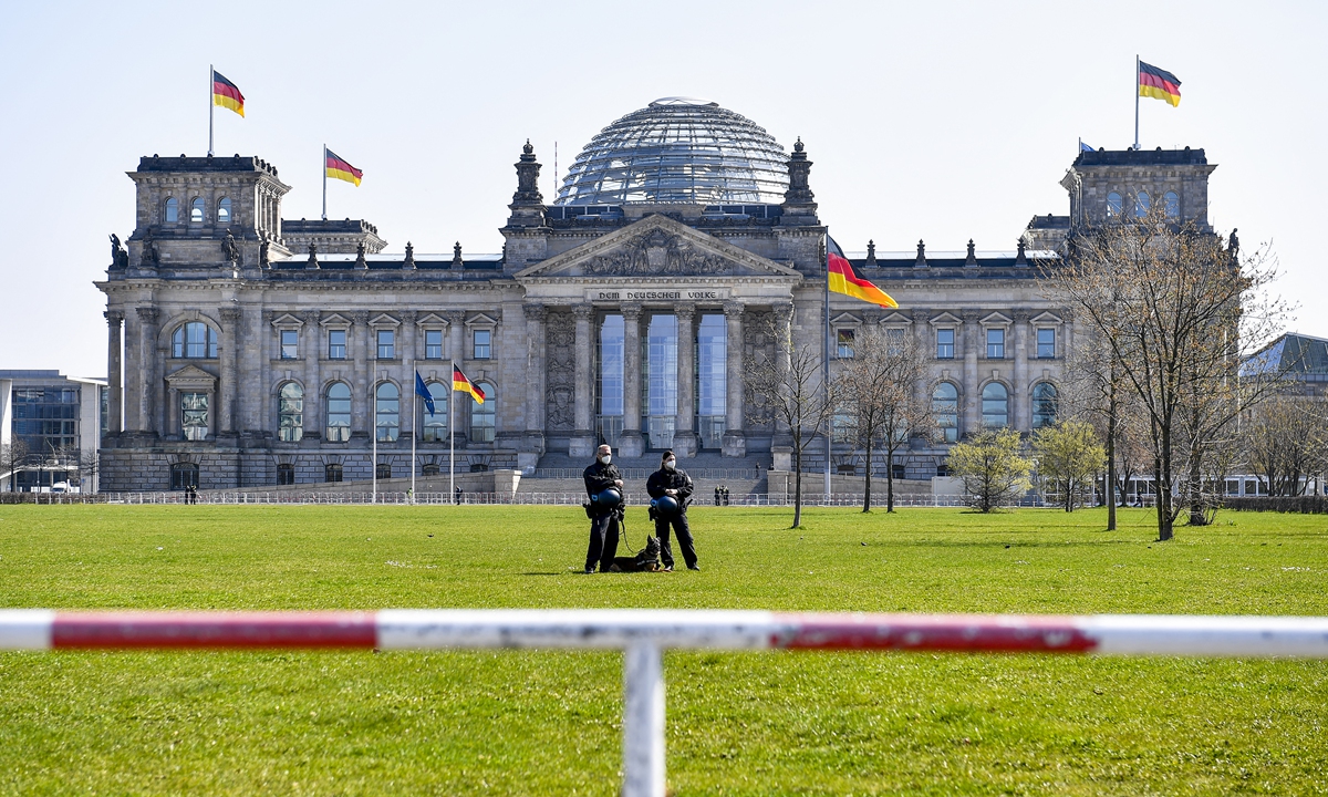Two police officers and a dog patrol behind a barrier guarding the Bundestag, Germany's lower house of parliament, in Berlin on Wednesday. An anti-COVID-19 lockdown demonstration was under way as German parliament members debate and vote on a national infections control law. Photo: AFP