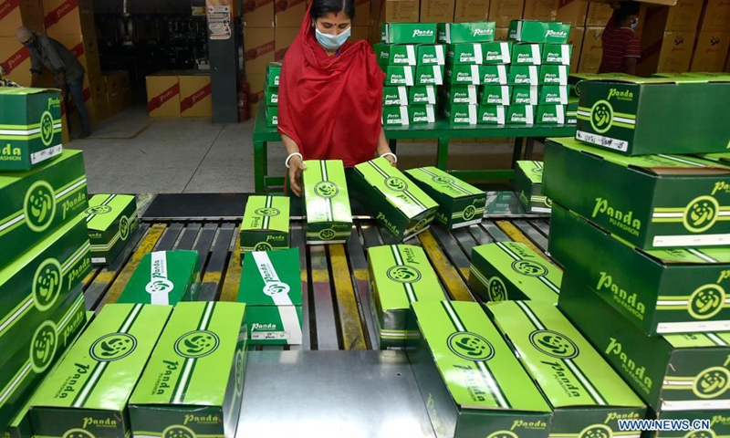 A worker packs products of Panda Shoes Industries Ltd. in Gazipur on the outskirts of Dhaka, Bangladesh, April 4, 2021. Thousands of households in the Gazipur District on the outskirts of the Bangladeshi capital Dhaka have become better off after a Chinese-invested shoemaking factory opened there in 2012. Panda Shoes Industries Ltd. has not only brought investment and development opportunities to the Gazipur District, but also provided jobs at villagers' doorsteps.(Photo: Xinhua)