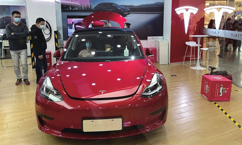 People sit inside a Tesla car displayed at a store in Beijing. Photos: VCG