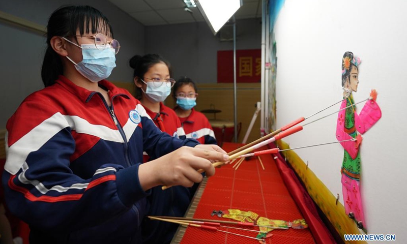 Students play with shadow puppets at the No. 6 Middle School in Shahe City, north China's Hebei Province, April 21, 2021. The middle school has invited local artists to introduce the traditional shadow play to students as a part of effort to have its students better know intangible culture heritage.(Photo: Xinhua)