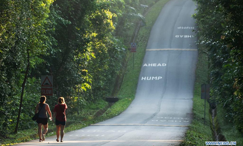 People walk on a road in the forest of Singapore's Central Catchment Nature Reserve on April 21, 2021.(Photo: Xinhua)