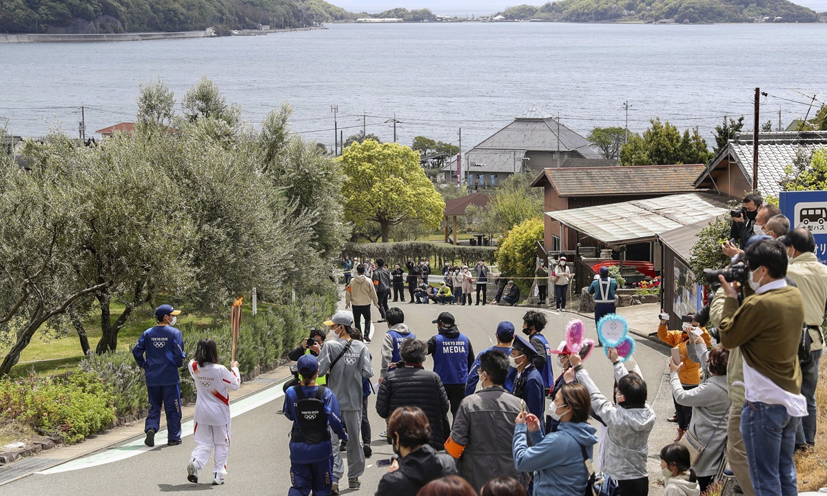 A Tokyo Olympic torch relay participant runs in Shodoshima Island in Kagawa Prefecture, western Japan, on April 18, 2021. Photo: VCG
