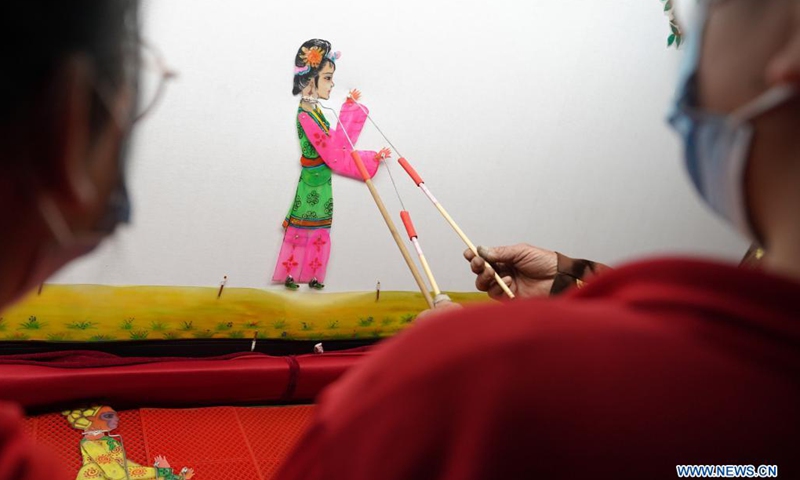 A student plays with a shadow puppet at the No. 6 Middle School in Shahe City, north China's Hebei Province, April 21, 2021. The middle school has invited local artists to introduce the traditional shadow play to students as a part of effort to have its students better know intangible culture heritage.(Photo: Xinhua)
