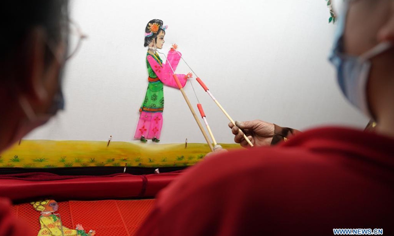 A student plays with a shadow puppet at the No. 6 Middle School in Shahe City, north China's Hebei Province, April 21, 2021. The middle school has invited local artists to introduce the traditional shadow play to students as a part of effort to have its students better know intangible culture heritage.(Photo: Xinhua)