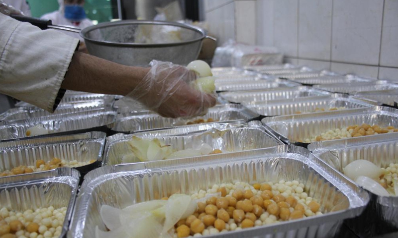 A volunteer of a charity organization packs Ramadan food to distribute to the poor for free in Tripoli, Lebanon, on April 22, 2021. Photo:Xinhua