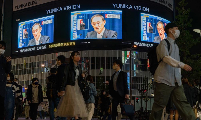 Japan's Prime Minister Yoshihide Suga is shown on outdoor screens during a press conference as he declares a state of emergency over COVID-19 in Tokyo, Japan on April 23, 2021. Yoshihide Suga on Friday declared a third state of emergency over COVID-19 in Tokyo, Osaka, Kyoto and Hyogo. The state of emergency will come into effect from Sunday to May 11. Photo:Xinhua