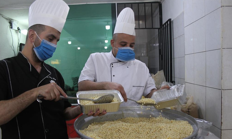 Volunteers of a charity organization pack Ramadan food to distribute to the poor for free in Tripoli, Lebanon, on April 22, 2021.Photo:Xinhua