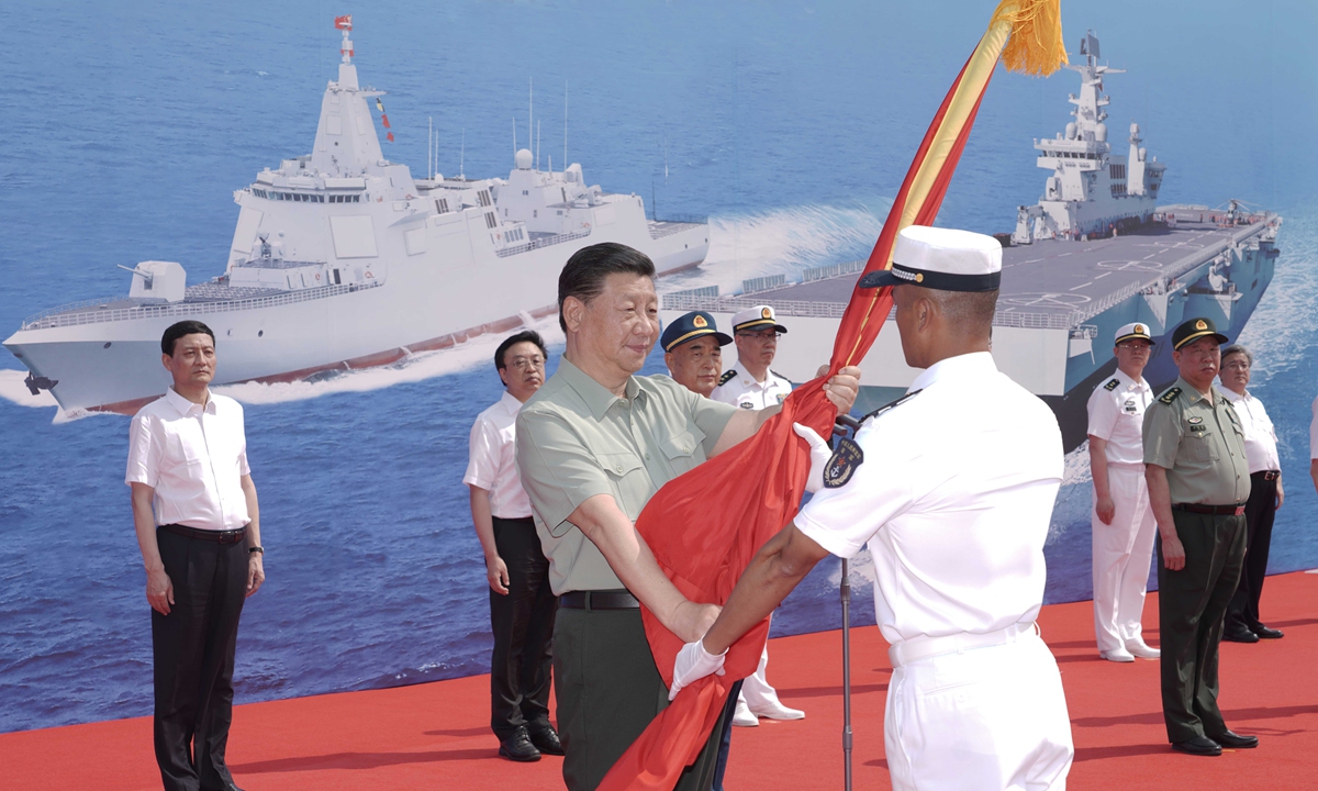 President Xi Jinping presents a PLA flag to the newly commissioned Changzheng 18 warship at a port in Sanya, South China's Hainan Province, on Friday. Photo: Xinhua

