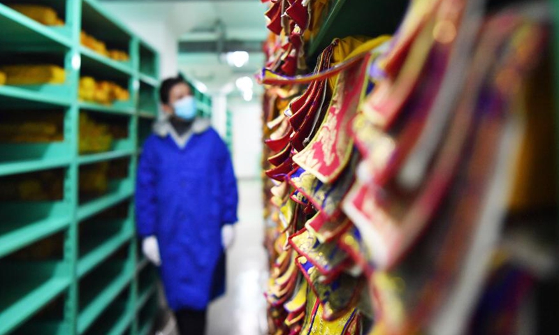 A staff member with the regional ancient book protection center checks rare ancient books in Lhasa, southwest China's Tibet Autonomous Region, April 21, 2021.Photo:Xinhua
