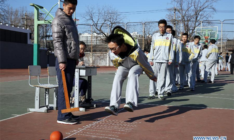 A student does the standing long jump during the final physical education tests at No.2 Middle School in Beijing. (Photo: Xinhua)