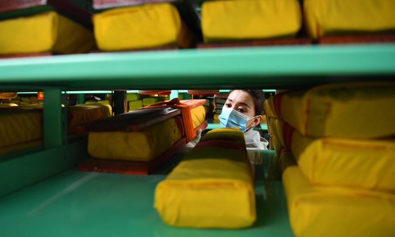 A staff member with the regional ancient book protection center arranges rare ancient books in Lhasa, southwest China's Tibet Autonomous Region, April 21, 2021.Photo:Xinhua