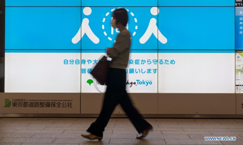 A woman walks past a social distancing signage in Tokyo, Japan on April 23, 2021. Japan's Prime Minister Yoshihide Suga on Friday declared a third state of emergency over COVID-19 in Tokyo, Osaka, Kyoto and Hyogo. The state of emergency will come into effect from Sunday to May 11.Photo:Xinhua