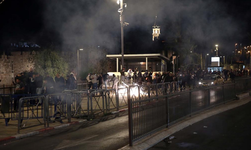 People react during clashes between Palestinians and Israelis in east Jerusalem, on April 22, 2021. Dozens of people were injured and dozens more arrested as clashes erupted between Palestinians and Israelis in east Jerusalem on Thursday night.Photo:Xinhua