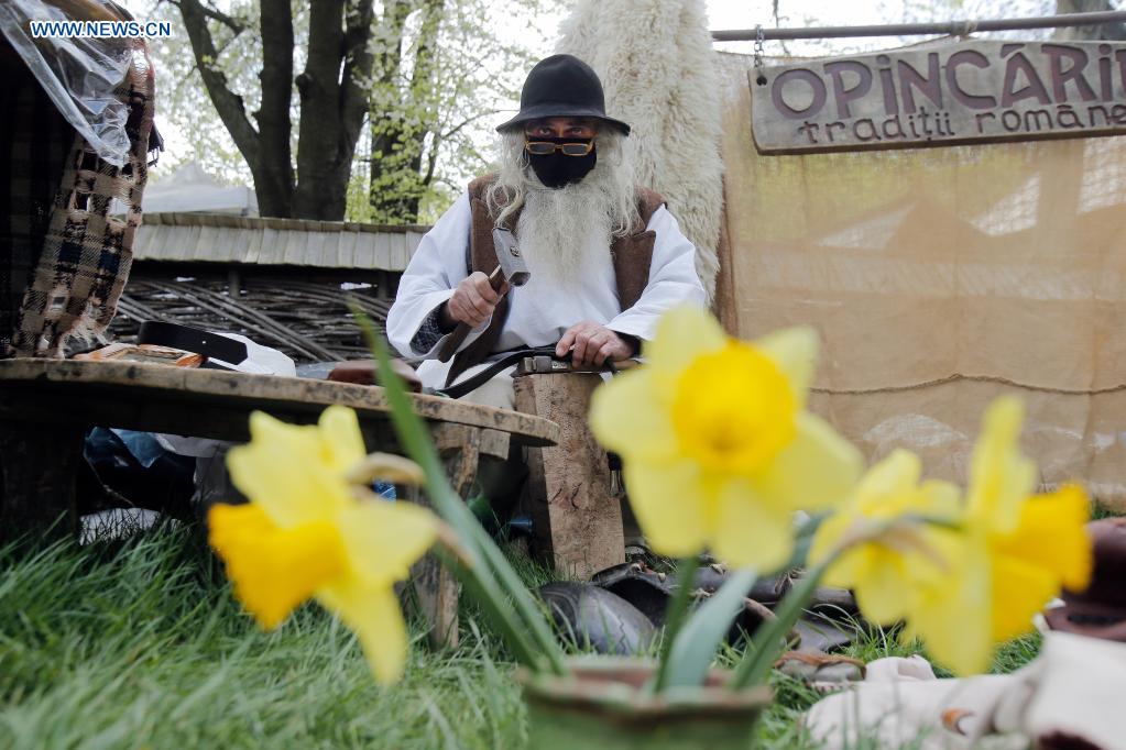 An artisan waits for customers during a traditional spring handmade craft fair organised at Romania's Village Museum in Bucharest, Romania, April 24, 2021. Artisans from all around the country arrived at the Village Museum to prove their crafting talents and to sell their goods.(Photo: Xinhua)