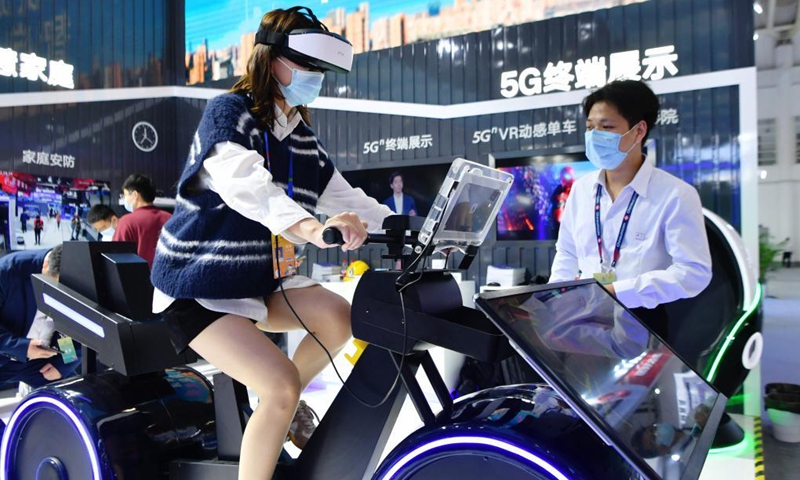 A visitor tries a VR spinning based on 5G technology at the digital achievements exhibition during the fourth Digital China Summit in Fuzhou, southeast China's Fujian Province, April 25, 2021. (Photo: Xinhua)