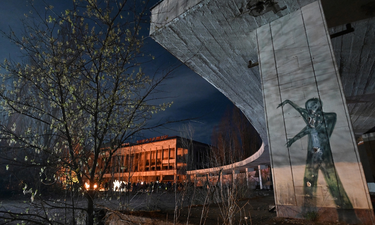 People gather on the central square of the ghost town of Pripyat near the Chernobyl Nuclear Power Plant early on Monday to commemorate the 35th anniversary of the Chernobyl nuclear disaster. A 2005 UN report estimated that up to 4,000 people could eventually perish from the invisible poison in Ukraine, Russia and Belarus. Photo: AFP