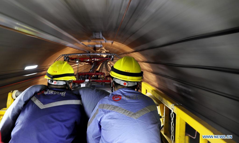 Technicians take part in the cold-running test at a section of Shanghai Metro Line 18 in east China