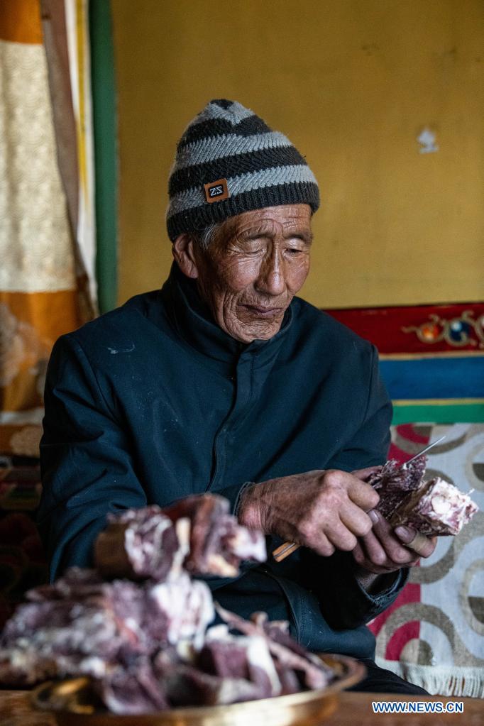 Tsering eats dried beef at home in Nyinzhung Township of Damxung County, Lhasa City of southwest China's Tibet Autonomous Region, April 16, 2021.(Photo:Xinhua)