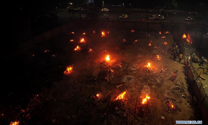 Burning funeral pyres are seen during a mass cremation for those who died from the COVID-19 at a crematorium in Delhi, India, on April 26, 2021.(Photo: Xinhua)