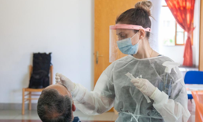 A medical worker wearing protective gear takes a swab sample from a man for COVID-19 test in Nicosia, Cyprus, April 27, 2021.(Photo: Xinhua)