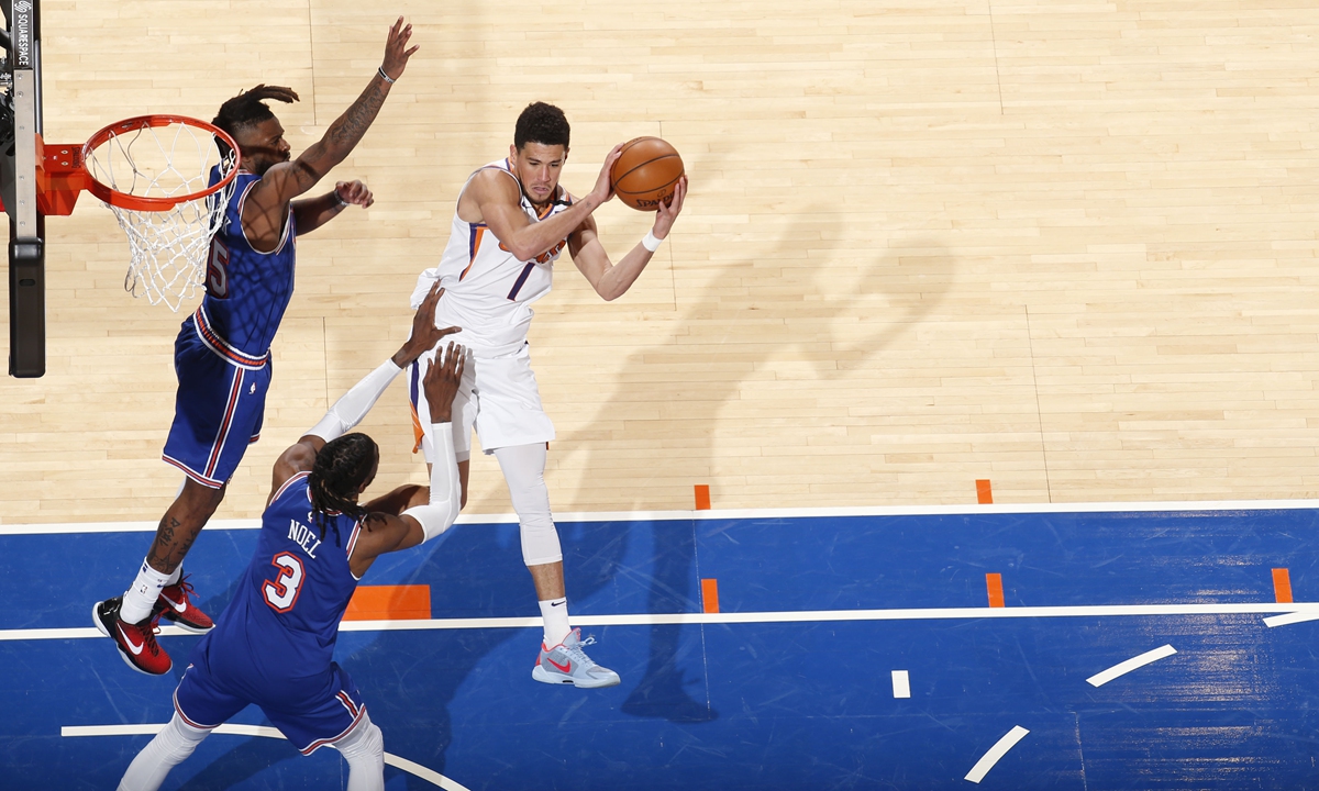 Devin Booker of the Phoenix Suns passes the ball during the game against the New York Knicks on Monday in New York City. Photo: AFP