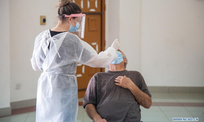 A medical worker wearing protective gear takes a swab sample from a man for COVID-19 test in Nicosia, Cyprus, April 27, 2021.(Photo: Xinhua)