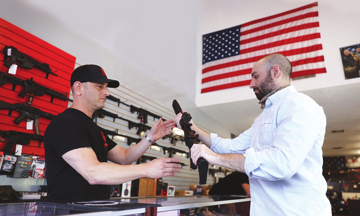 Brandon Wexler (left) helps Austin Title as he looks at weapons at WEX Gunworks in Delray Beach, Florida, the US, on March 24. Photo: VCG