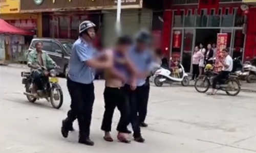 The suspect attacker was arrested by police officer in Beiliu, South China's Guangxi Province on Wednesday. Photo: screenshot of online video