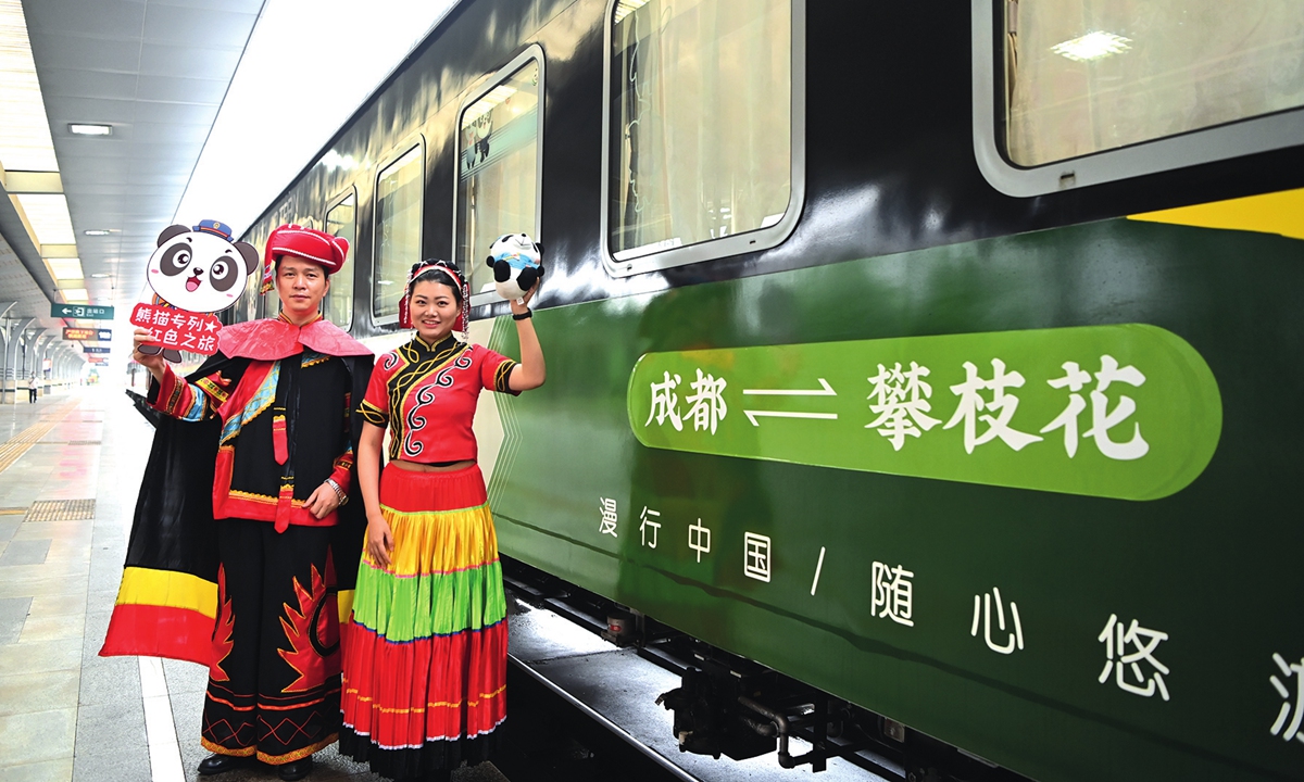 A special train for red-themed tourism from Chengdu to Panzhihua in Southwest China's Sichuan Province firstly pulls out in April. Train staff in ethnic groups' costume welcome passengers at the front of the carriages. Photo: CNSphoto