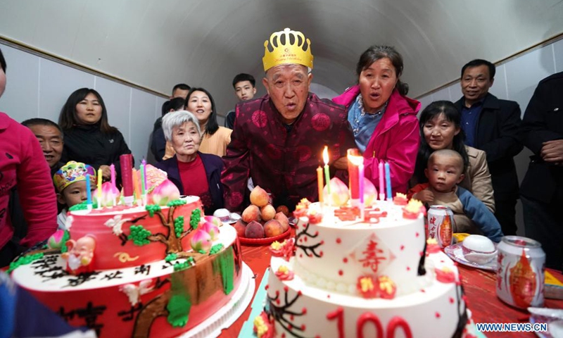 Hu Zaizhong blows candles on his birthday cake at his birthday banquet at Xuejiawan Village, Liulin County, Lyuliang City of north China's Shanxi Province, on April 24, 2021. Hu Zaizhong, who has just turned 100, vividly remembers his wishes at different stages of his life: having decent food and clothing in his early days, teaching as many pupils as he could in his prime age, and enjoying quality time with his family for late years.(Photo: Xinhua)
