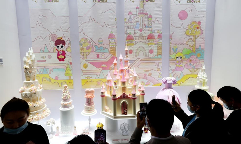 Visitors watch a collection of fairy tales-themed cakes on the Bakery China 2021 exhibition at the Shanghai New International Expo Centre in east China's Shanghai, April 27, 2021. The exhibition opened here on Tuesday where more than 2,300 exhibitors in the bakery industry showcased their products, services and technologies.Photo:Xinhua