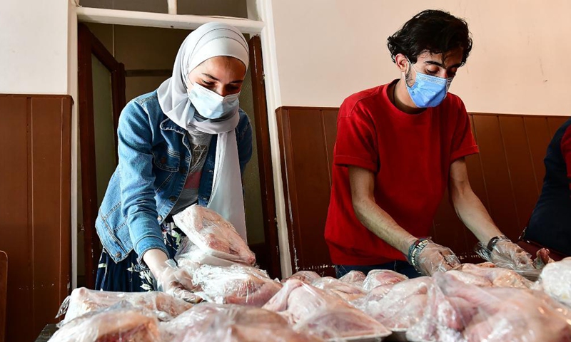 Volunteers prepare charity food during the holy month of Ramadan in Damascus, Syria, on April 20, 2021. As Syria is passing through a tough economic crisis, some charity kitchens started working during the holy month of Ramadan to help people save money by offering free meals and food parcels.Photo:Xinhua