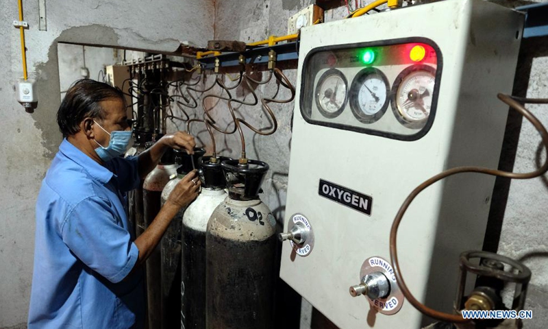 A hospital worker adjusts the oxygen cylinders to supply oxygen through the central pipeline for the patients at a private hospital in Kolkata, India, April 28, 2021.Photo:Xinhua