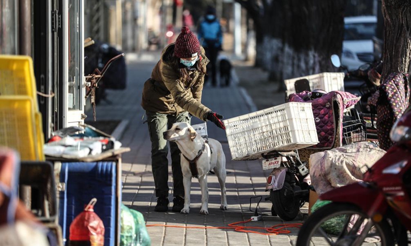 Trainer Wang Lin trains a guide dog on a street in Dalian, northeast China's Liaoning Province, Jan. 14, 2020.Photo:Xinhua
