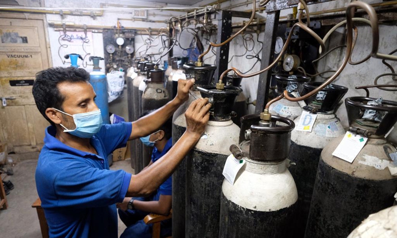 A hospital worker adjusts the oxygen cylinders to supply oxygen through the central pipeline for the patients at a private hospital in Kolkata, India, April 28, 2021.Photo:Xinhua