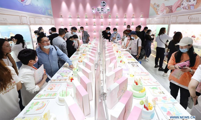 Visitors watch accessory materials for cakes on the Bakery China 2021 exhibition at the Shanghai New International Expo Centre in east China's Shanghai, April 27, 2021. The exhibition opened here on Tuesday where more than 2,300 exhibitors in the bakery industry showcased their products, services and technologies.Photo:Xinhua