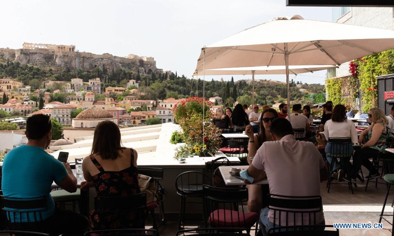 People are seen at a cafe at the foot of the Acropolis, in Athens, Greece, May 3, 2021. Cafeterias, restaurants and bars reopened on Monday across Greece in a festive atmosphere after a six-month shutdown due to the COVID-19 restrictions. The country's second lockdown, which started on Nov. 7, 2020, is gradually being eased this spring, as the number of new infections has stabilized lately and vaccinations continue. (Xinhua/Marios Lolos)