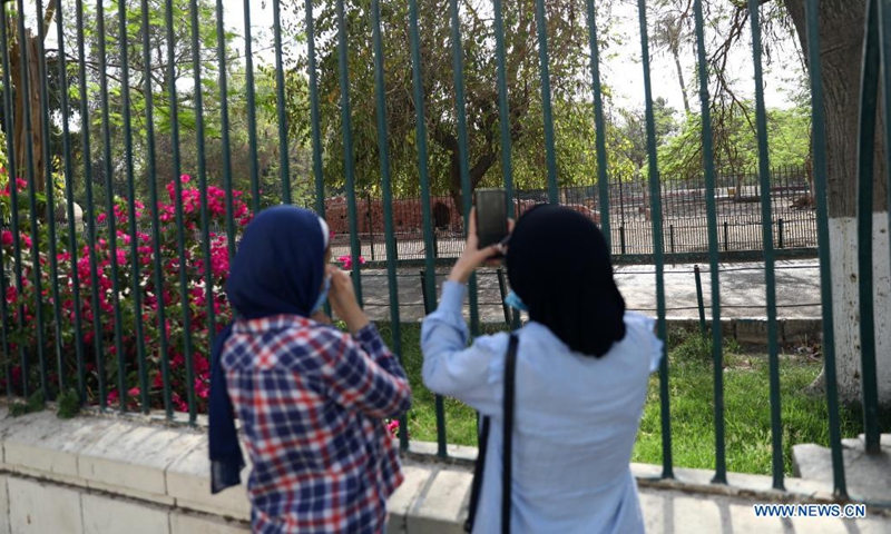 A woman takes photos outside the closed Giza Zoo during the Sham El-Nessim in Giza, Egypt, on May 3, 2021. Several Egyptian governors, including governor of Cairo, issued directives on April 30 to close public parks and beaches ahead of the Sham El-Nessim, the traditional Egyptian spring festival which falls on May 3 this year, as the country has witnessed a surge in coronavirus cases. (Xinhua/Ahmed Gomaa) 
