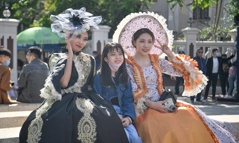 A tourist (C) poses for a group photo with performers at the Italian Style Area in Hebei District of north China's Tianjin, May 1, 2021. (Xinhua/Sun Fanyue)