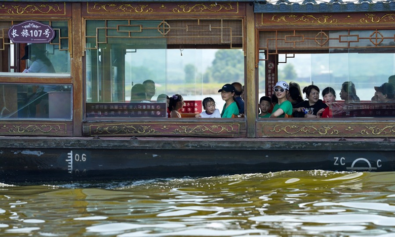 Tourists have fun riding a boat at the Changshou Lake scenic area in southwest China's Chongqing, on May 2, 2021. (Xinhua/Liu Chan)
