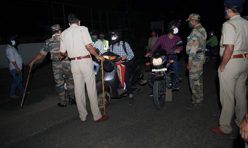 Police and TSR (Tripura State Rifles) personnel check vehicles along a road during a night curfew imposed by the state government amidst rising COVID-19 cases in Agartala, the capital city of India's northeastern state of Tripura, May 4, 2021. (Photo: Xinhua)