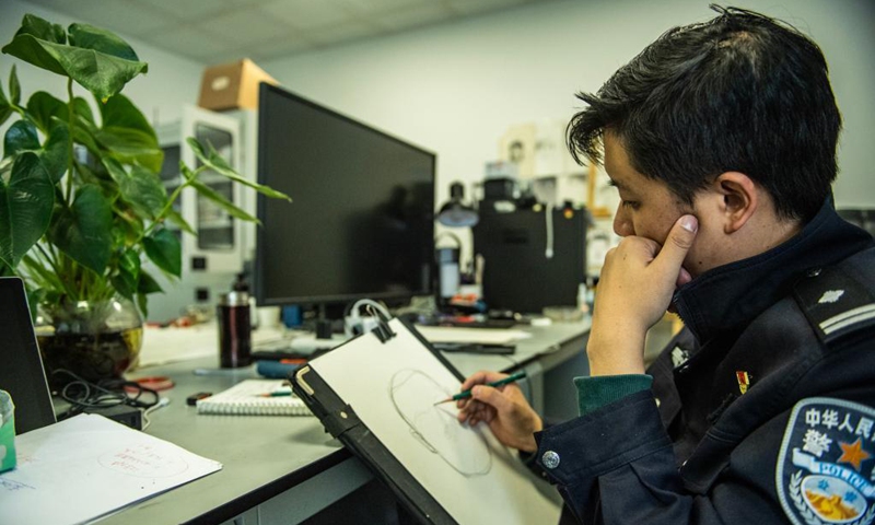 Zhu Yunhong profiles a possible suspect at large in his office at the criminal detective division of the Guiyang Public Security Bureau in Guiyang, southwest China's Guizhou Province, May 2, 2021.(Photo: Xinhua)