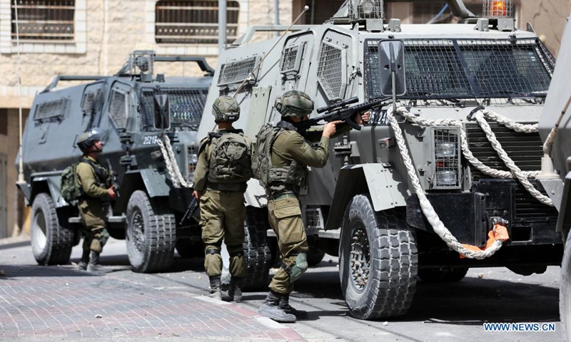 Israeli soldiers take part in a security operation to search for Palestinians suspected in a drive-by shooting attack, in Aqraba village, east of the West Bank city of Nablus, on May 4, 2021. A drive-by shooting attack in the West Bank on Sunday afternoon injured three Israelis, including two in critical condition, Israeli authorities said. (Photo by Ayman Nobani/Xinhua)