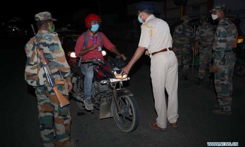 Police and TSR (Tripura State Rifles) personnel check vehicles along a road during a night curfew imposed by the state government amidst rising COVID-19 cases in Agartala, the capital city of India's northeastern state of Tripura, May 4, 2021. (Photo: Xinhua)