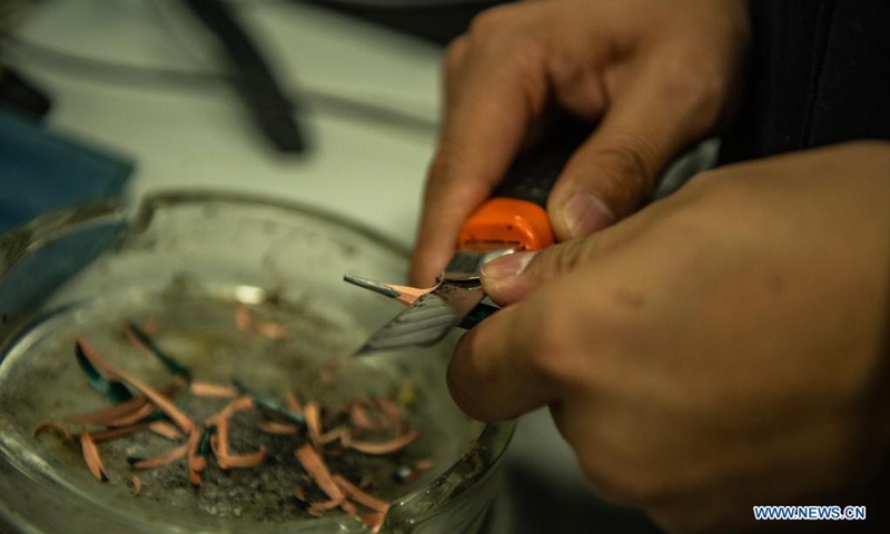 Zhu Yunhong sharpens a pencil in his office at the criminal detective division of the Guiyang Public Security Bureau in Guiyang, southwest China's Guizhou Province, May 2, 2021.(Photo: Xinhua)