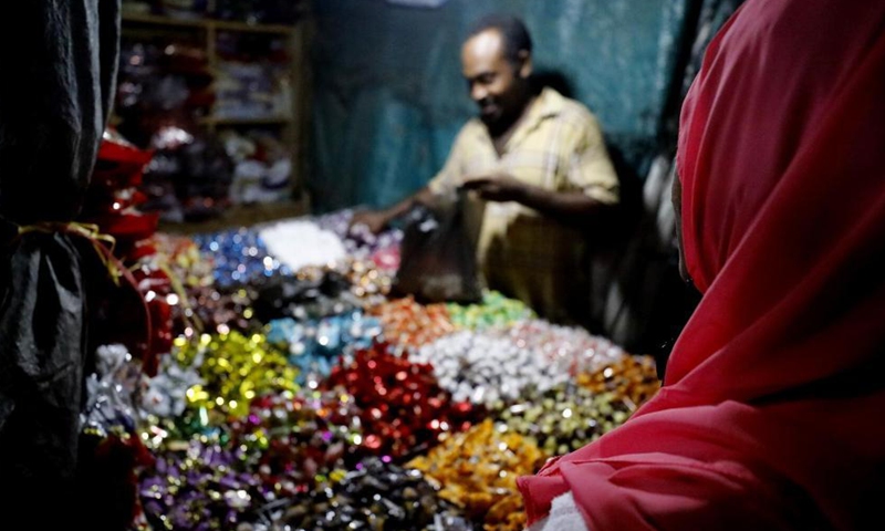 A vendor sells sweets at a market in Khartoum, Sudan, May 5, 2021. Eid Al-Fitr, also called the festival of breaking the fast that marks the end of the month-long dawn-to-sunset fasting of Ramadan, is celebrated by Muslims worldwide. Photo: Xinhua