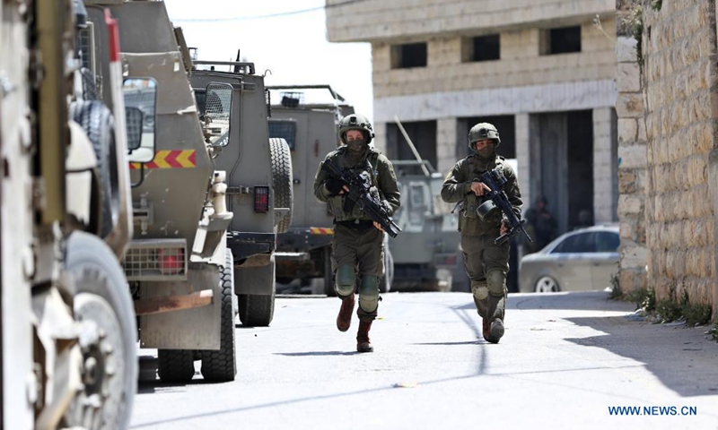 Israeli soldiers take part in a security operation to search for Palestinians suspected in a drive-by shooting attack, in Aqraba village, east of the West Bank city of Nablus, on May 4, 2021. A drive-by shooting attack in the West Bank on Sunday afternoon injured three Israelis, including two in critical condition, Israeli authorities said. (Photo by Ayman Nobani/Xinhua)