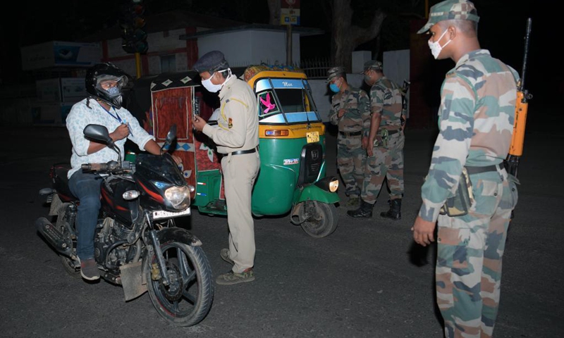 Police and TSR (Tripura State Rifles) personnel check vehicles along a road during a night curfew imposed by the state government amidst rising COVID-19 cases in Agartala, the capital city of India's northeastern state of Tripura, May 4, 2021. (Photo: Xinhua)